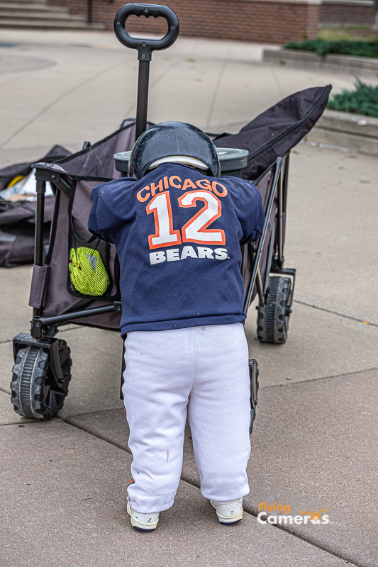 Pouting Chicao Bear doll on cart with baseball equipment
