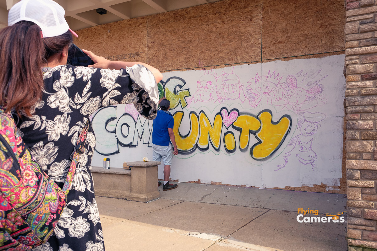 Photographer captures an image of a photographer capturing an image of a mural being drawn