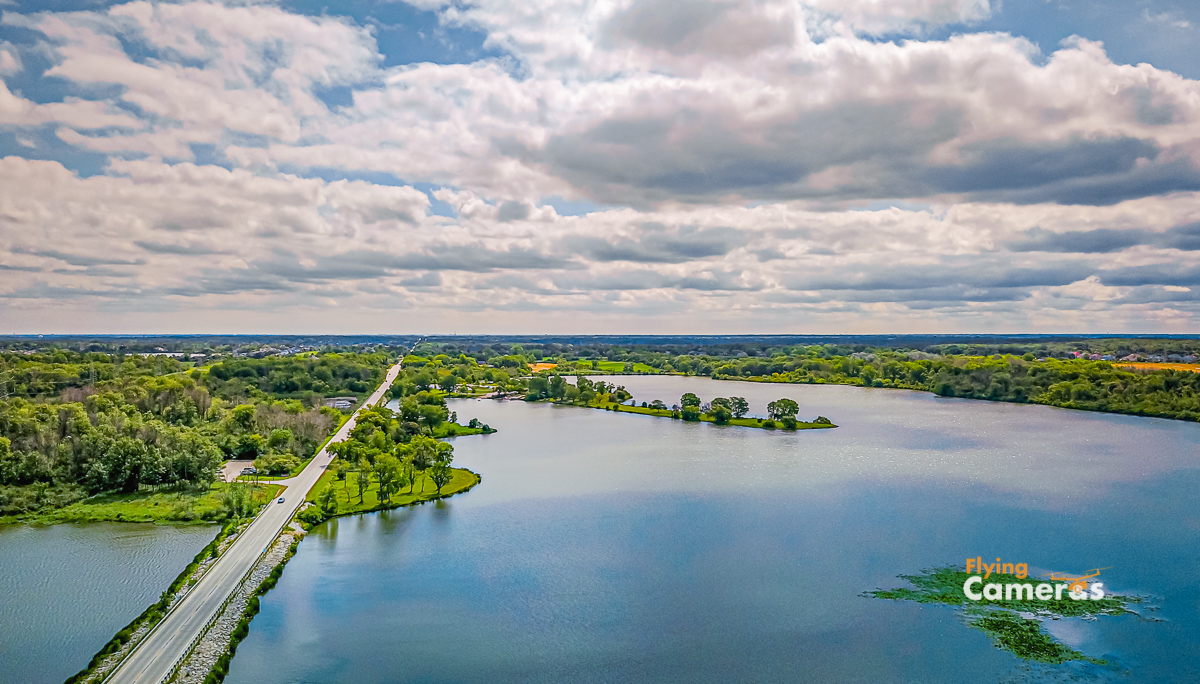 Aerial Image of the blue water of Tampier lake near Orland Park taken at 250 ft elevation with a cloudy and sunny blue sky